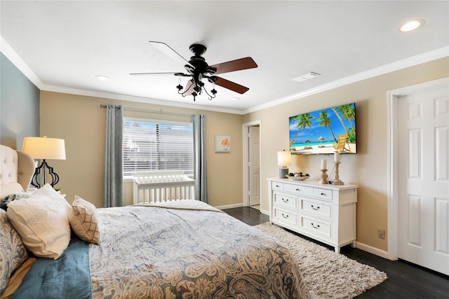 bedroom featuring dark hardwood / wood-style flooring, ceiling fan, and crown molding