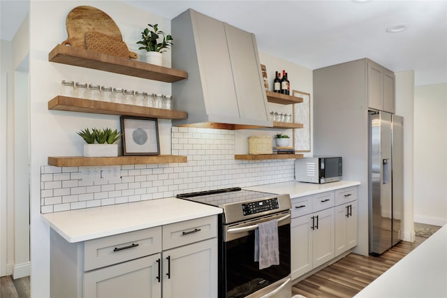 kitchen with decorative backsplash, light hardwood / wood-style flooring, and appliances with stainless steel finishes