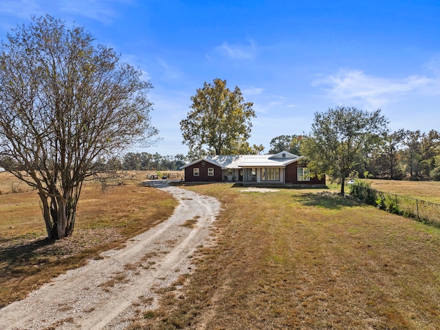 view of front of property with a rural view and a front lawn