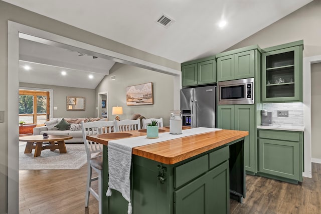 kitchen with a kitchen island, dark hardwood / wood-style floors, green cabinets, vaulted ceiling, and appliances with stainless steel finishes