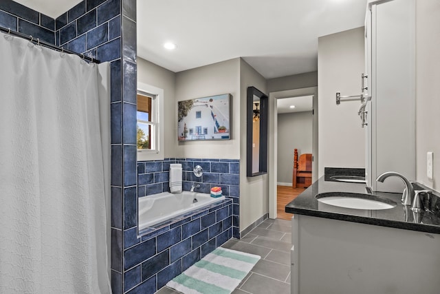 bathroom featuring vanity, tile patterned floors, and tiled tub