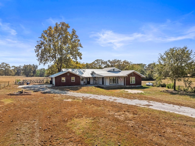 ranch-style house with a rural view and covered porch