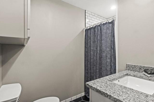 bathroom featuring toilet, vanity, a shower with shower curtain, and tile patterned flooring