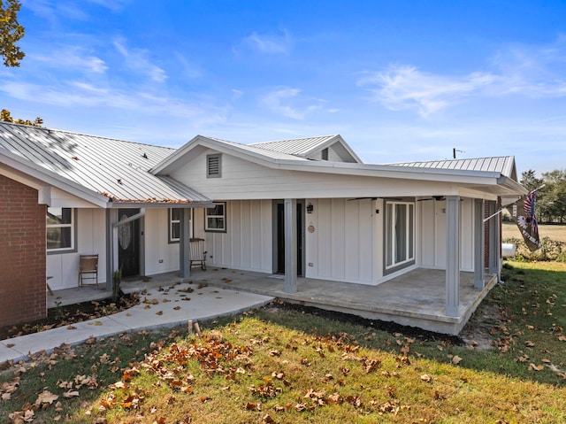 rear view of property featuring a patio area and a lawn