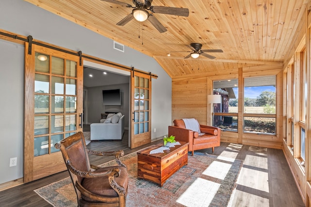 sunroom with ceiling fan, vaulted ceiling, wood ceiling, and a barn door