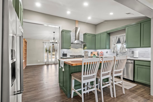 kitchen featuring wall chimney exhaust hood, wooden counters, green cabinets, and lofted ceiling