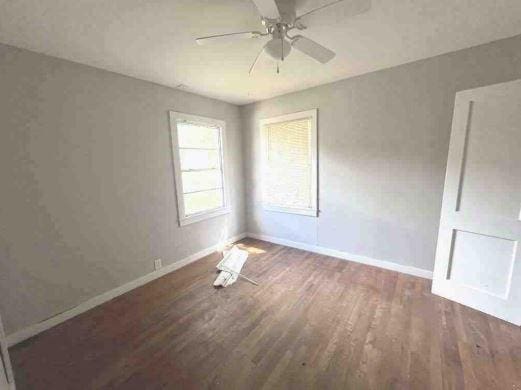 unfurnished bedroom featuring wood finished floors, baseboards, and ceiling fan