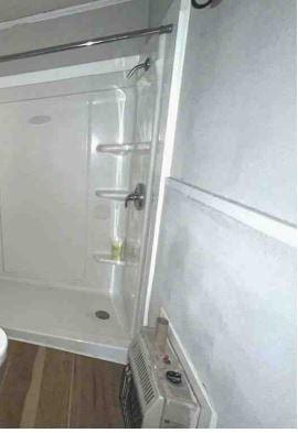 full bath featuring a stall shower, toilet, and wood finished floors