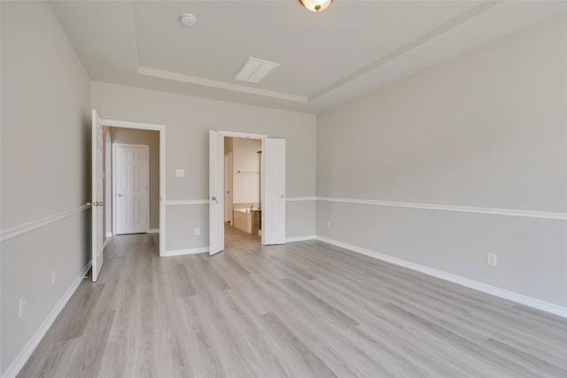 unfurnished bedroom featuring connected bathroom and light hardwood / wood-style floors