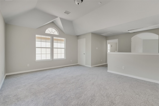 carpeted empty room featuring lofted ceiling