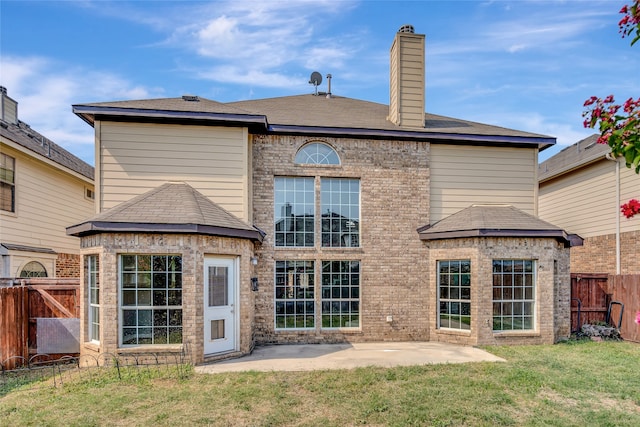 rear view of house with a patio and a lawn