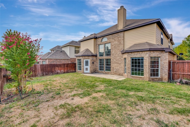 rear view of property with a patio and a lawn