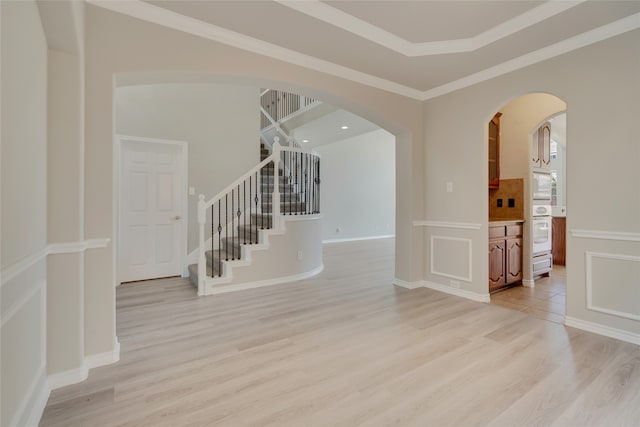 spare room featuring ornamental molding and light wood-type flooring