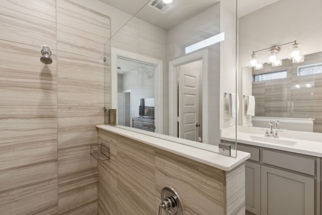 bathroom featuring vanity and tiled shower