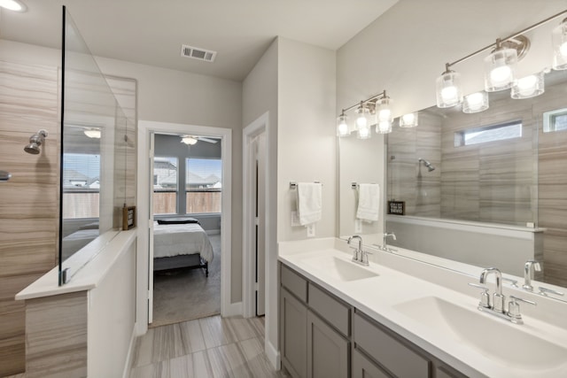 bathroom with vanity, tile patterned flooring, a tile shower, and ceiling fan