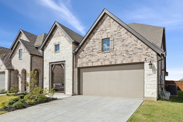 view of front of house with cooling unit, a front yard, and a garage