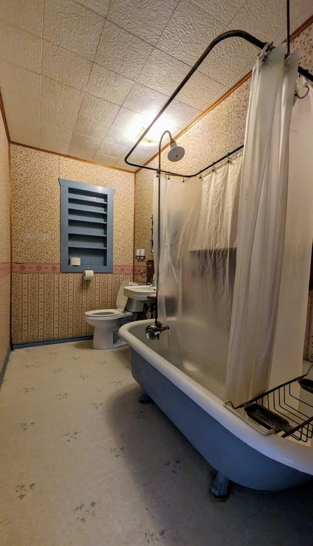 bathroom with toilet, concrete flooring, and shower / bath combo