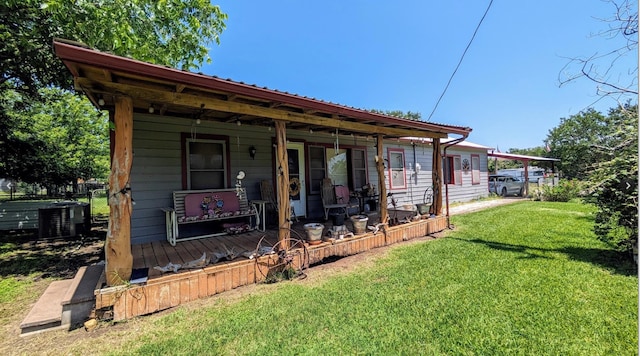 rear view of property with central AC unit and a lawn