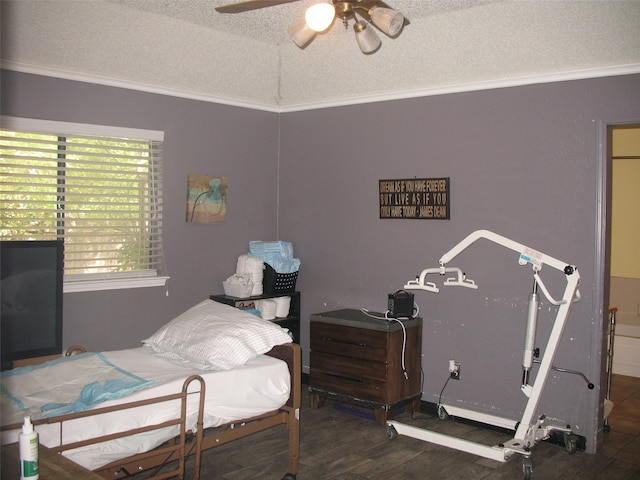 bedroom with dark wood-type flooring, a textured ceiling, ceiling fan, and crown molding