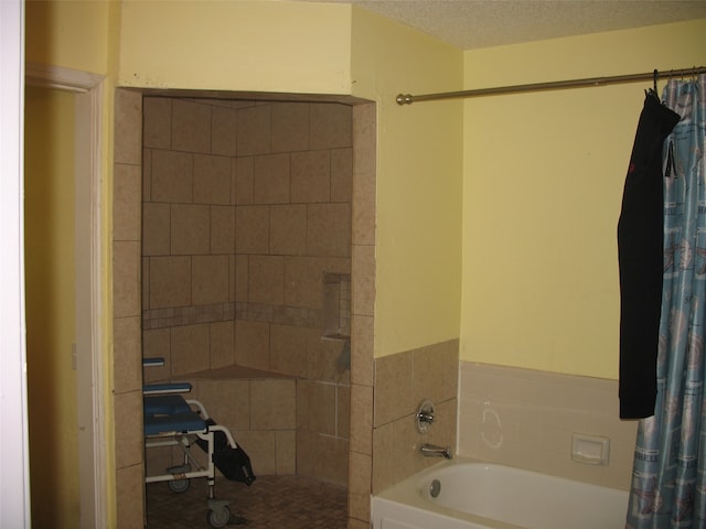 bathroom with plus walk in shower and a textured ceiling