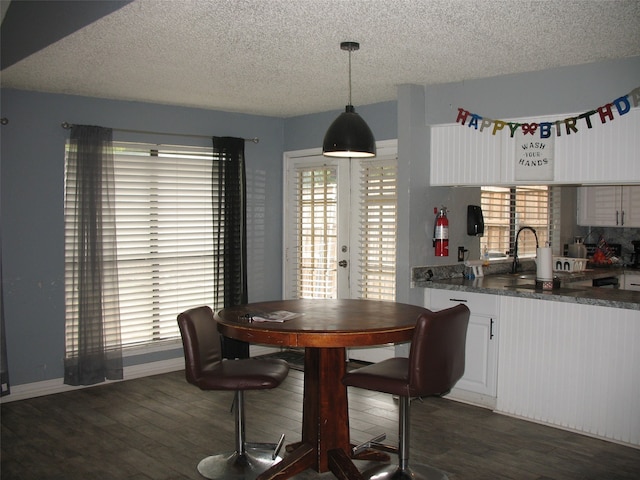 dining room featuring dark hardwood / wood-style flooring and a textured ceiling