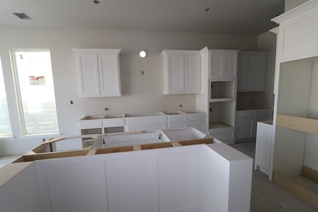 kitchen with white cabinets, a kitchen island, and a wealth of natural light