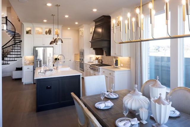 kitchen featuring tasteful backsplash, sink, an island with sink, stainless steel appliances, and pendant lighting