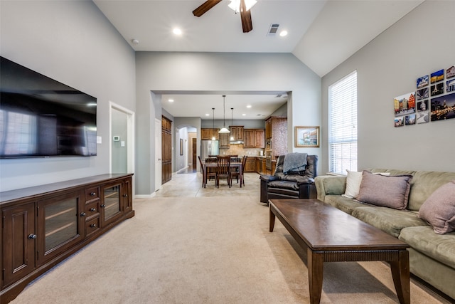 living room with light carpet, lofted ceiling, and ceiling fan