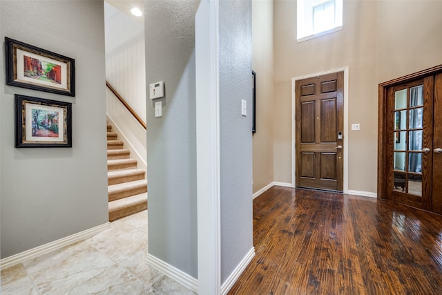 foyer entrance featuring hardwood / wood-style flooring and a high ceiling