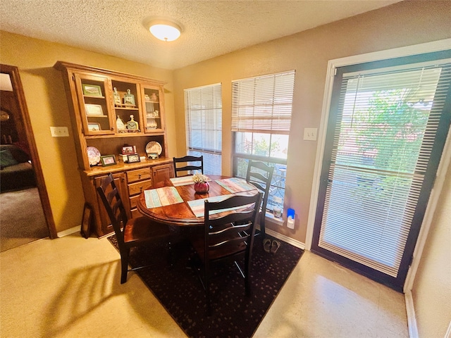 dining area featuring a healthy amount of sunlight and a textured ceiling