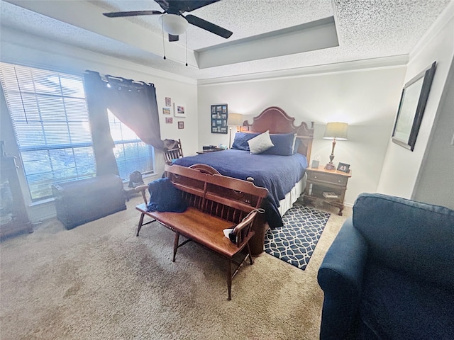 bedroom featuring ornamental molding, carpet flooring, a tray ceiling, and ceiling fan