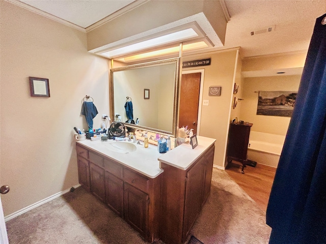 bathroom featuring vanity, crown molding, and a textured ceiling