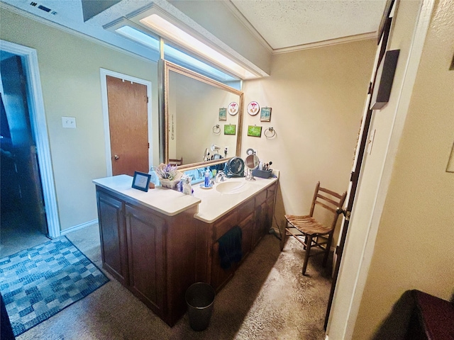 bathroom with vanity, ornamental molding, and a textured ceiling