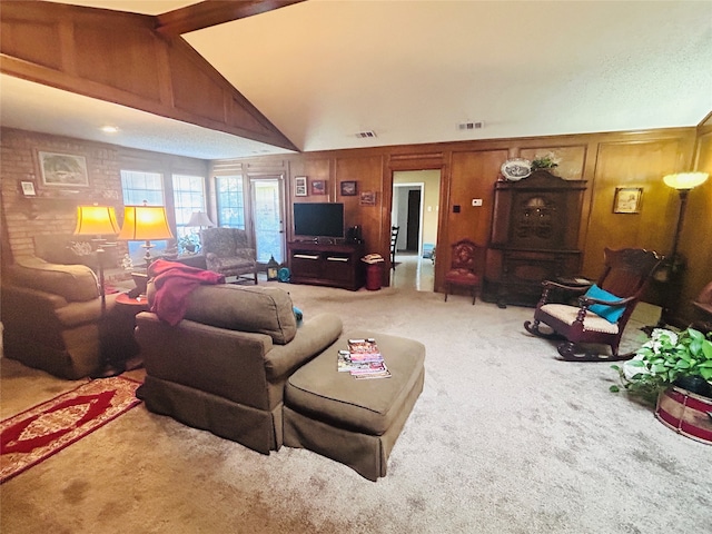 carpeted living room with lofted ceiling and wood walls