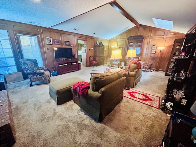 living room featuring wooden walls, vaulted ceiling with skylight, carpet flooring, and a textured ceiling