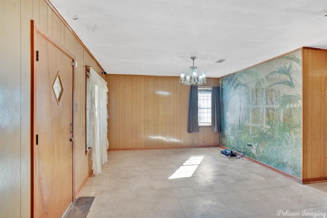 interior space with a notable chandelier and wood walls