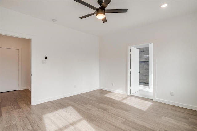 empty room with ceiling fan and light hardwood / wood-style flooring