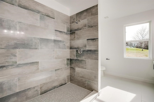 bathroom featuring tiled shower and toilet