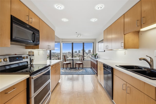 kitchen with sink, black appliances, and light wood-type flooring