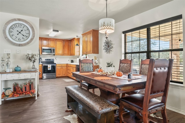 dining area with a notable chandelier, wood finished floors, and a healthy amount of sunlight