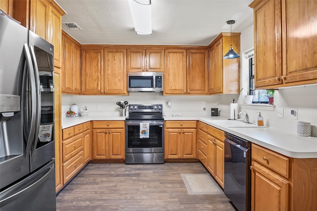 kitchen featuring stainless steel appliances, dark wood-type flooring, a sink, and visible vents