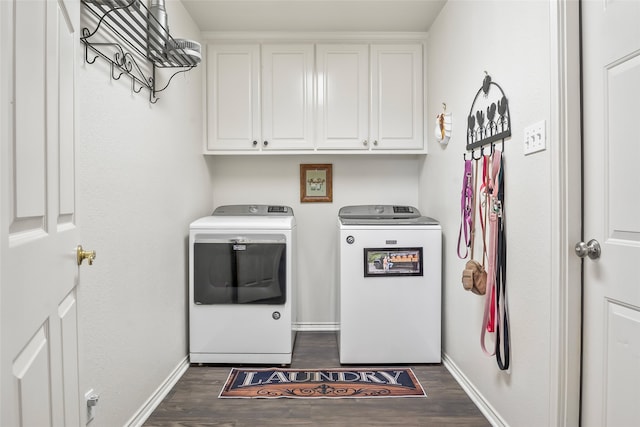 clothes washing area with dark wood-style floors, baseboards, cabinet space, and washer and dryer