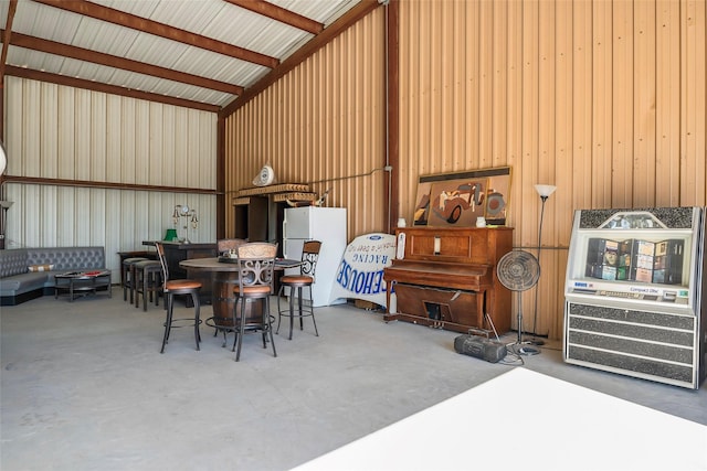 garage with metal wall and freestanding refrigerator