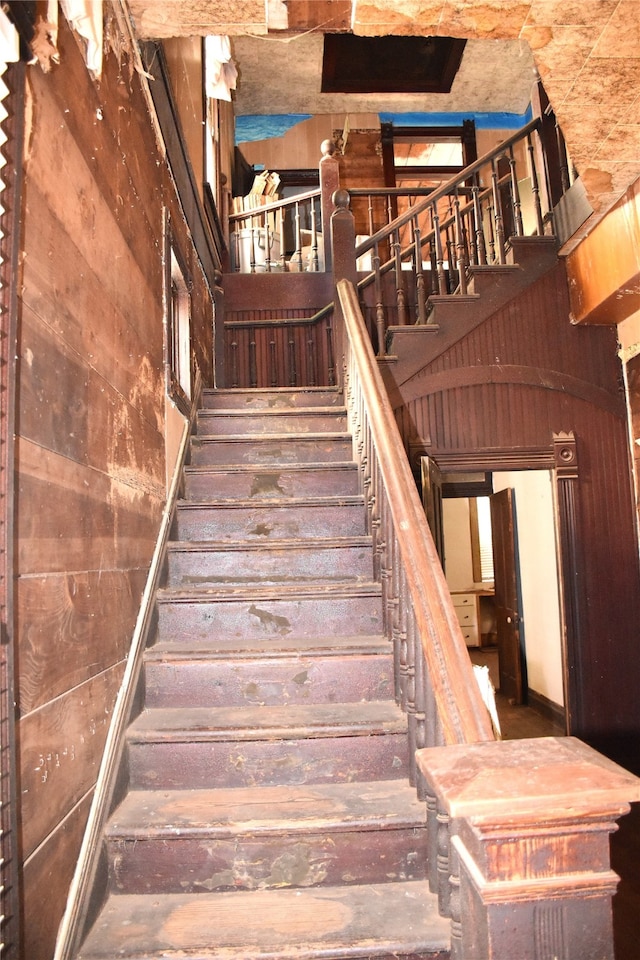 stairs featuring wood walls