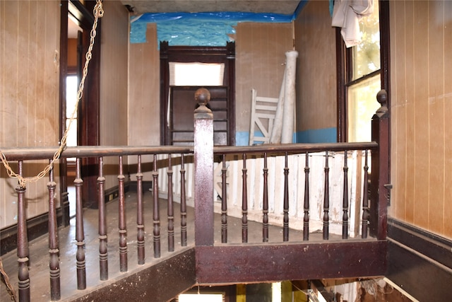 staircase featuring wooden walls