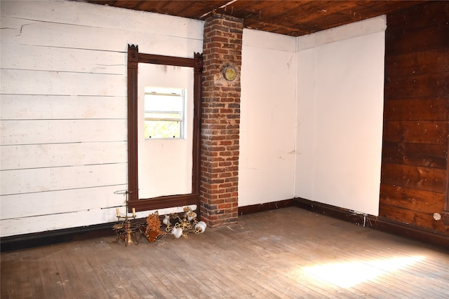 spare room featuring wood ceiling, wood walls, and dark hardwood / wood-style flooring