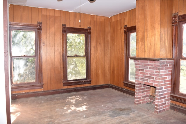 unfurnished living room with wooden walls, a fireplace, and hardwood / wood-style flooring