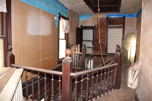 corridor with concrete floors and wood walls