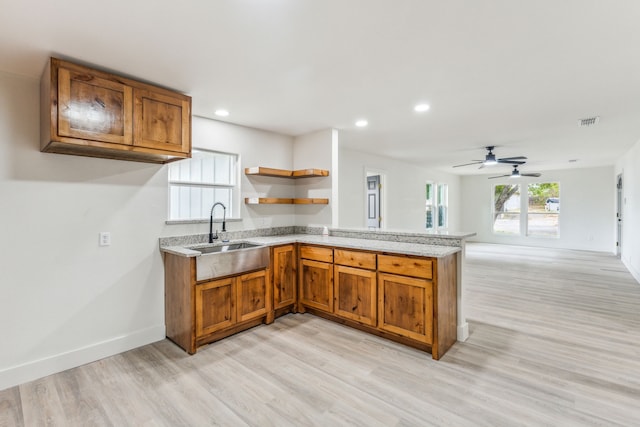 kitchen with ceiling fan, sink, and light hardwood / wood-style flooring