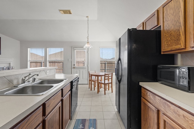 kitchen featuring lofted ceiling, sink, black appliances, pendant lighting, and light tile patterned floors